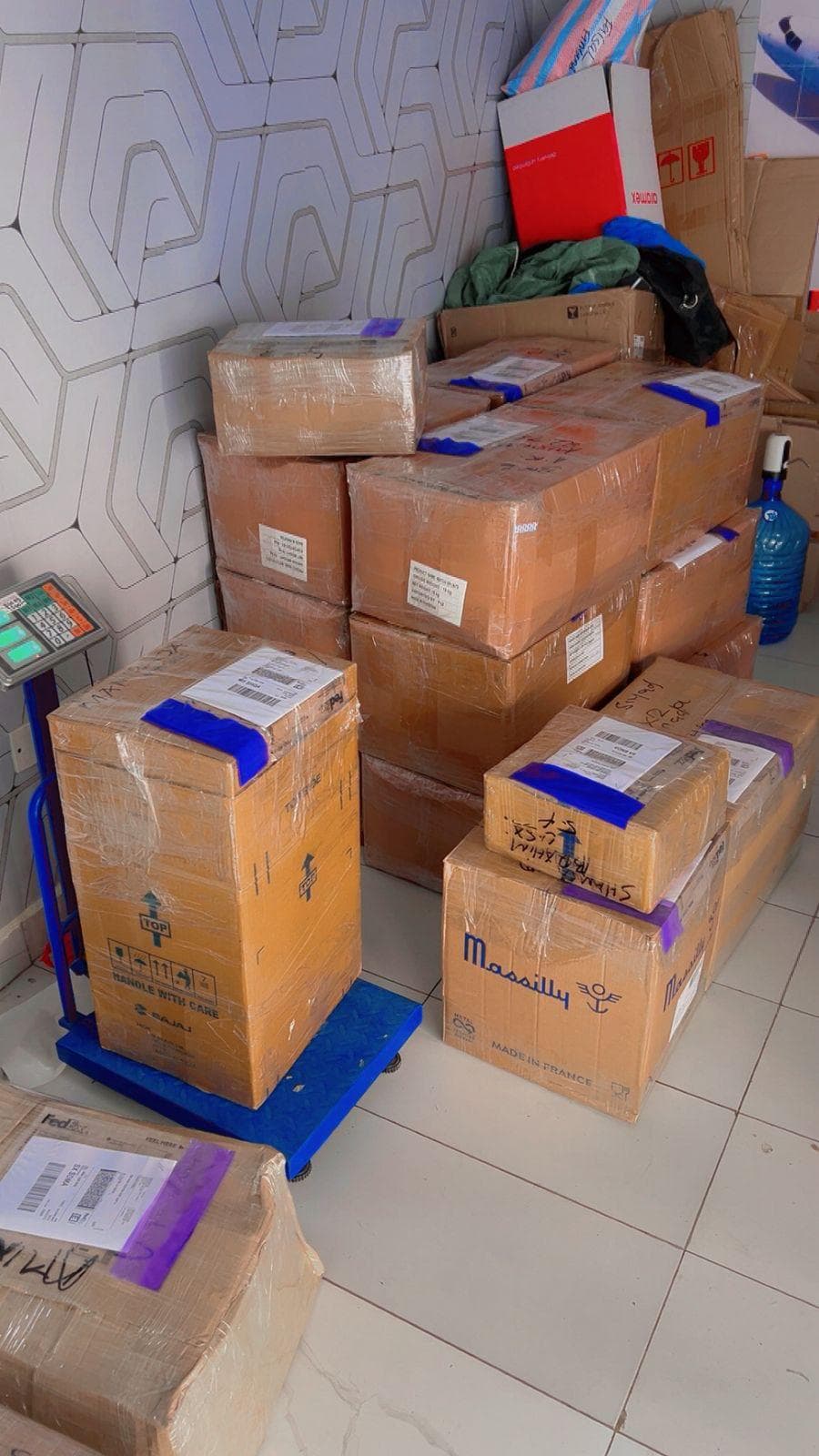 Stacked consolidation boxes beside the weighing scale and hand trolley